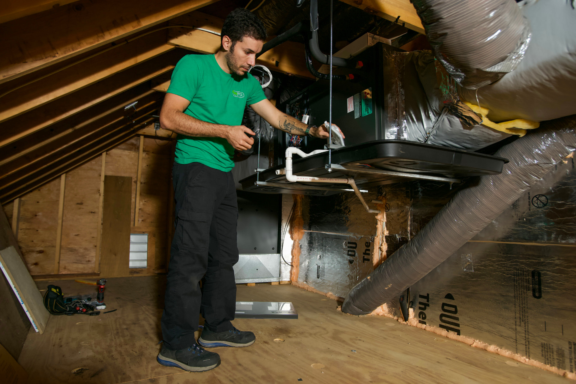 MJ Pro Energy technician servicing a Mitsubishi air handler in an attic