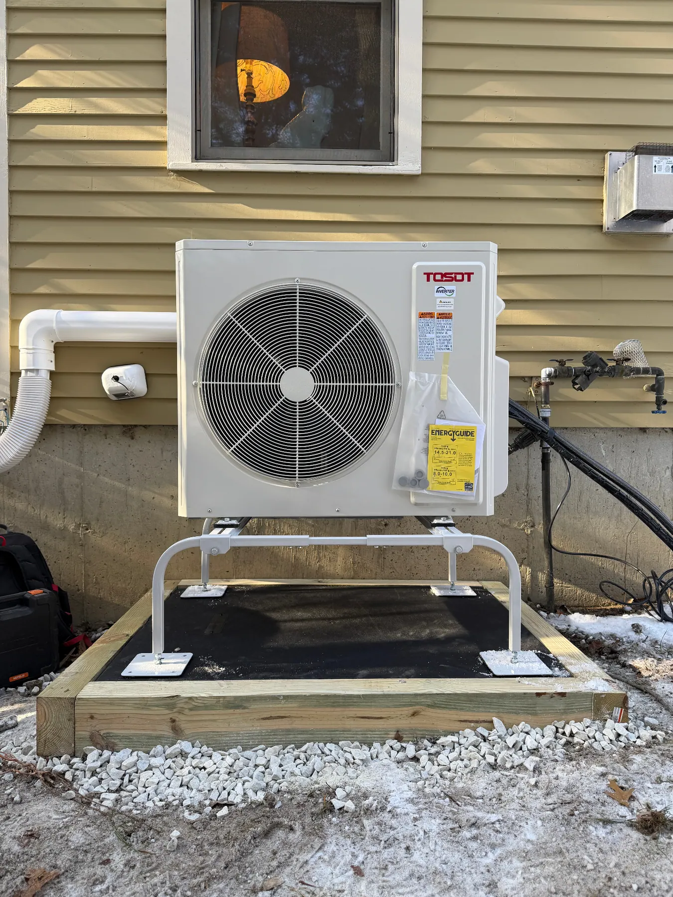 Central air condenser installed beside a home